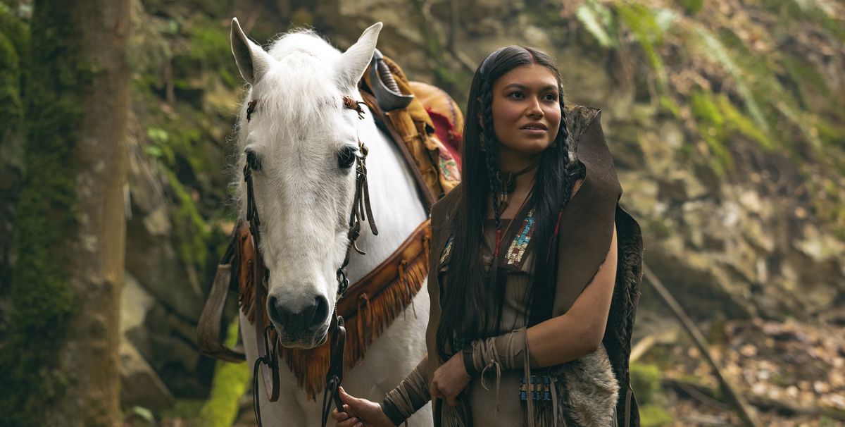 Alyssa Wapanatâhk as Tiger Lily in Peter Pan &amp; Wendy, standing next to a white horse in a forest