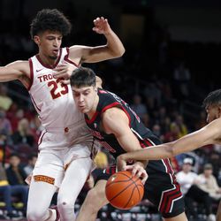 Southern California forward Isaiah Mobley, right, makes contact with Utah guard Lazar Stefanovic (20) as forward Max Agbonkpolo (23) defends during the first half of an NCAA college basketball game in Los Angeles, Wednesday, Dec. 1, 2021. 