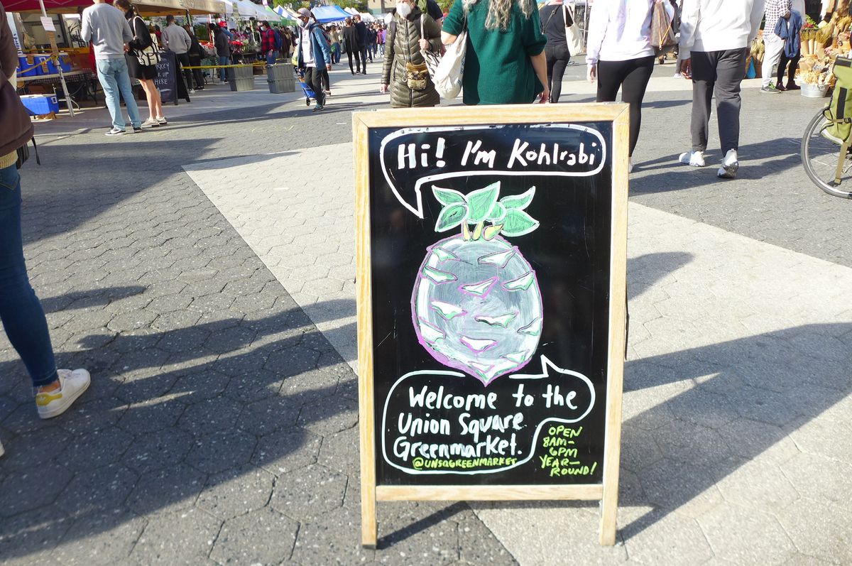 A chalkboard with a cartoon kohlrabi, which looks something like a turnip with a face.