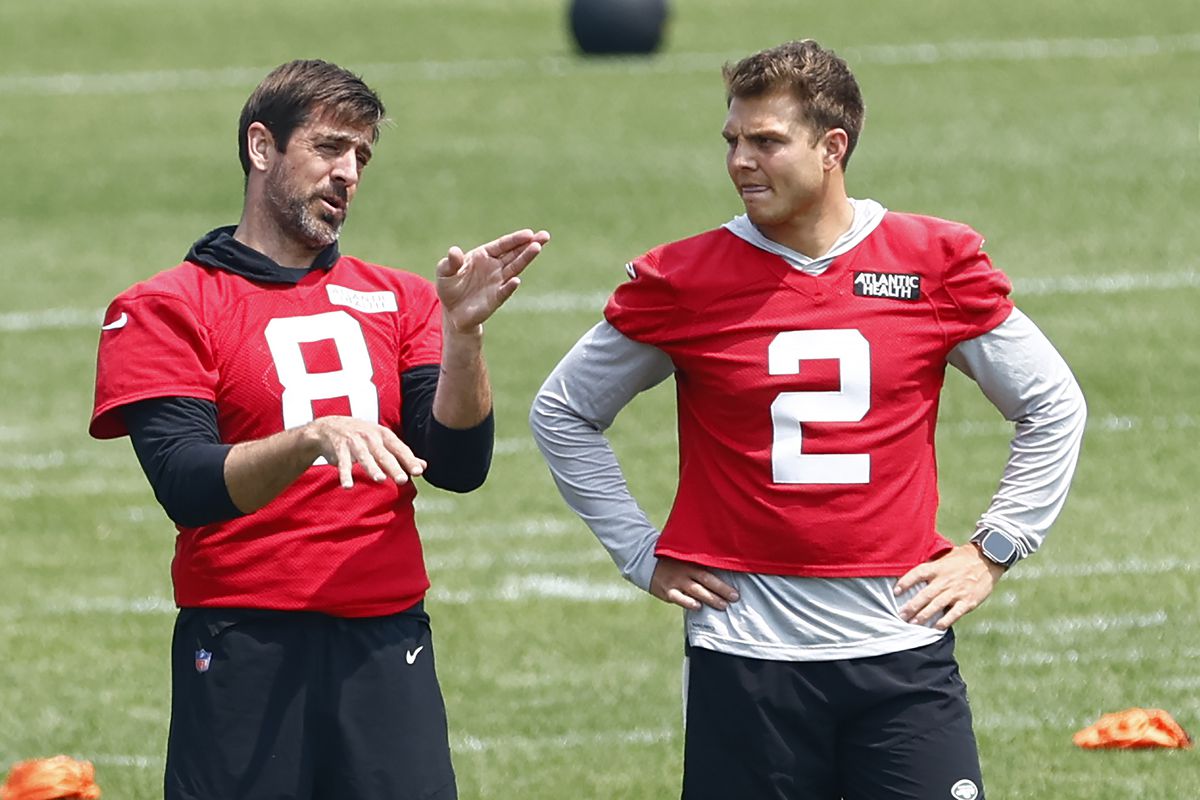Quarterbacks Aaron Rodgers #8 and Zach Wilson #2 of the New York Jets talk during the teams OTAs at Atlantic Health Jets Training Center on June 6, 2023 in Florham Park, New Jersey.