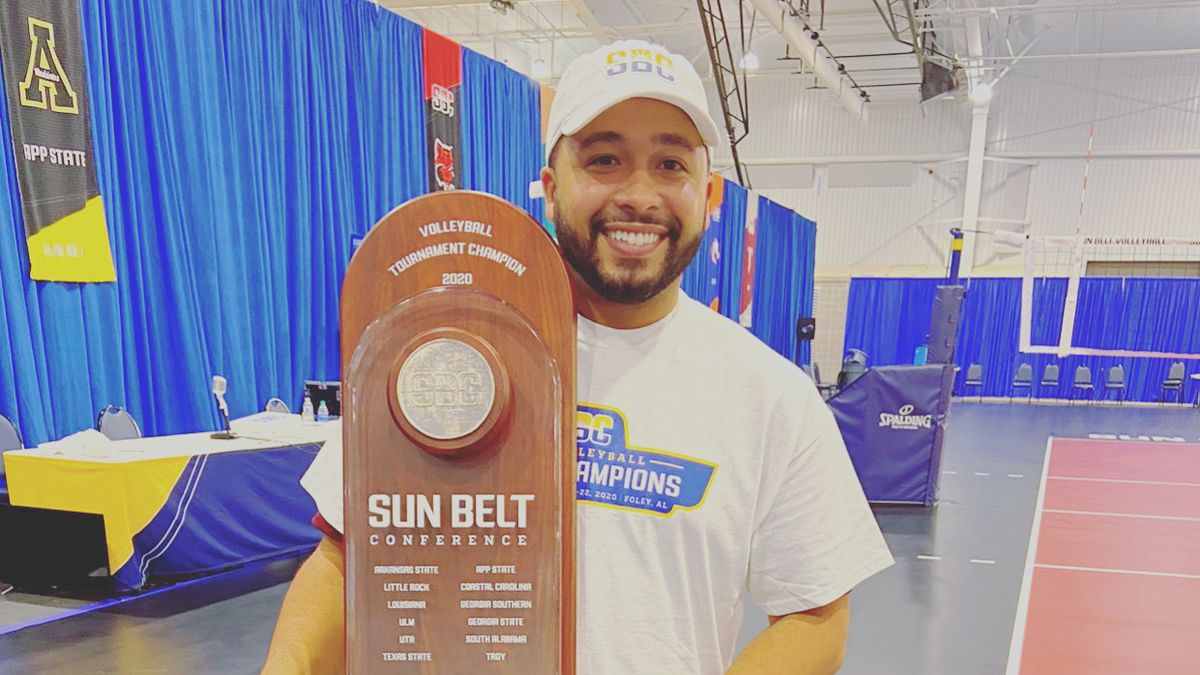 Keith Anderson with the Sun Belt trophy won by the Texas State volleyball team.