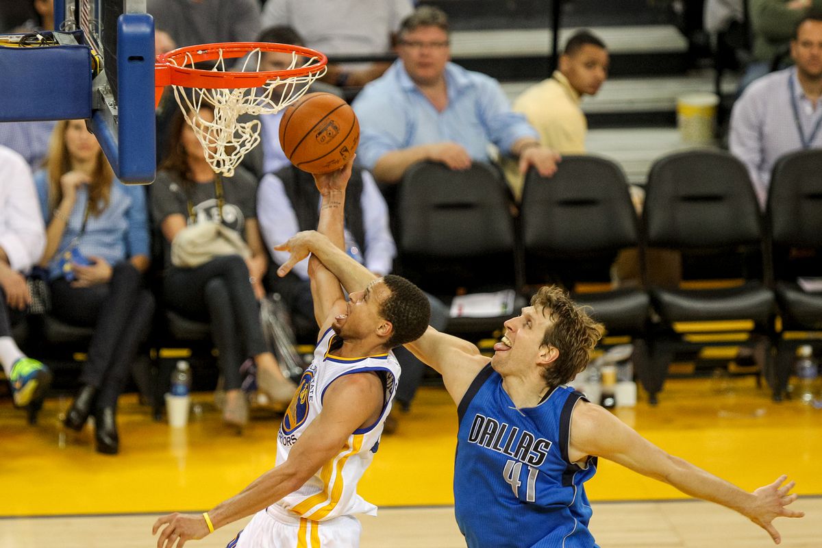 Golden State Warriors guard Stephen Curry (30) gets fouled by Dallas Mavericks forward Dirk Nowitzki (41) during the third quarter of an NBA game, Wednesday, Feb. 4, 2015, at the Oracle Arena in Oakland, Calif.