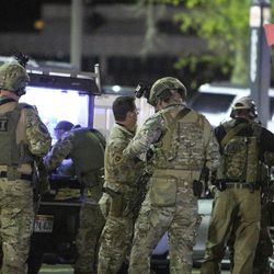FBI agents put on night vision goggles to begin searching for the suspect at the University of Utah in Salt Lake on Monday, Oct. 30, 2017.