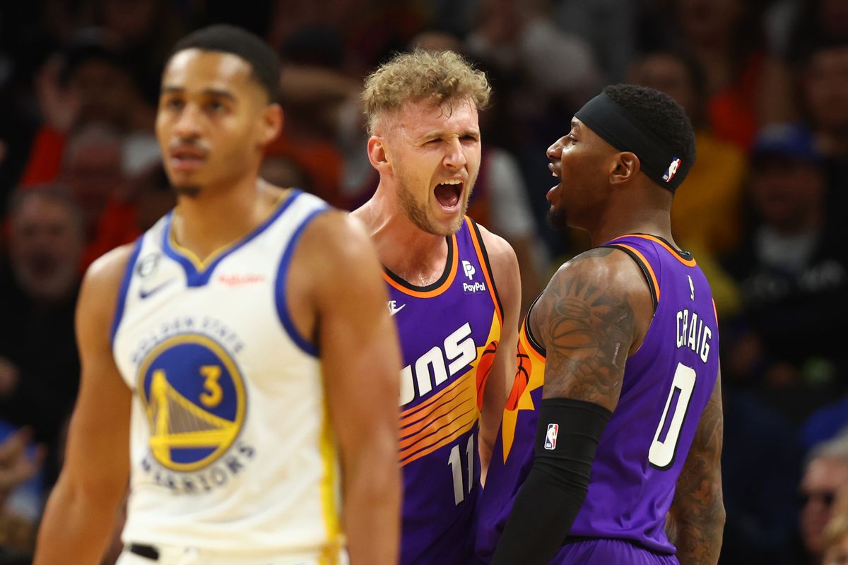 Phoenix Suns center Jock Landale (11) celebrates a play with Torrey Craig (0) as Golden State Warriors guard Jordan Poole (3) reacts in the second half at Footprint Center.