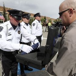 Jason Richman, a member of the Unified Police Department honor guard, returns the U.S. Honor Flag to a special case held by Chris Heisler, founder of the U.S. Honor Flag, during a ceremony at the department’s Holladay Precinct on Monday, Sept. 16, 2019. The flag was brought to Utah to honor fallen Unified police officer Doug Barney and fallen South Salt Lake police officer David Romrell. The flag has traveled over 7 million miles, by ground, air, and even in space, to honor America’s heroes.
