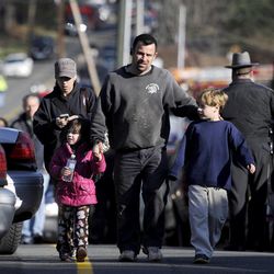 Parents leave a staging area after being reunited with their children following a shooting at the Sandy Hook Elementary School in Newtown, Conn., about 60 miles northeast of New York City, Friday, Dec. 14, 2012.