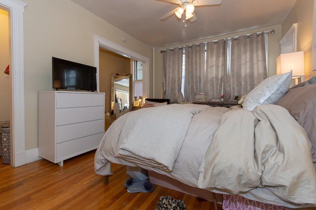 A studio apartment with a large bed taking up a lot of it.