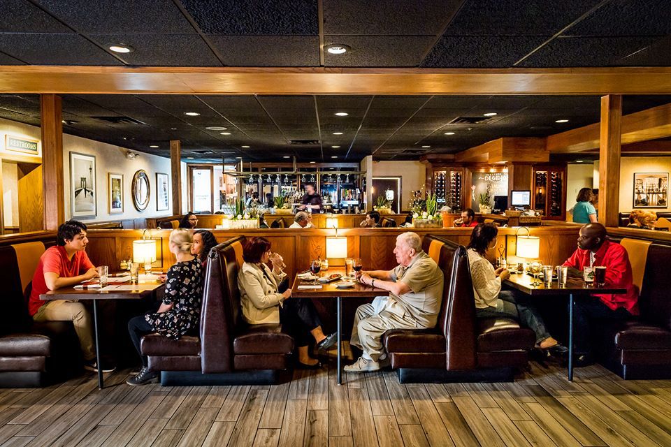 A cozy dining room with booths filled with people. This photo was taken last year.