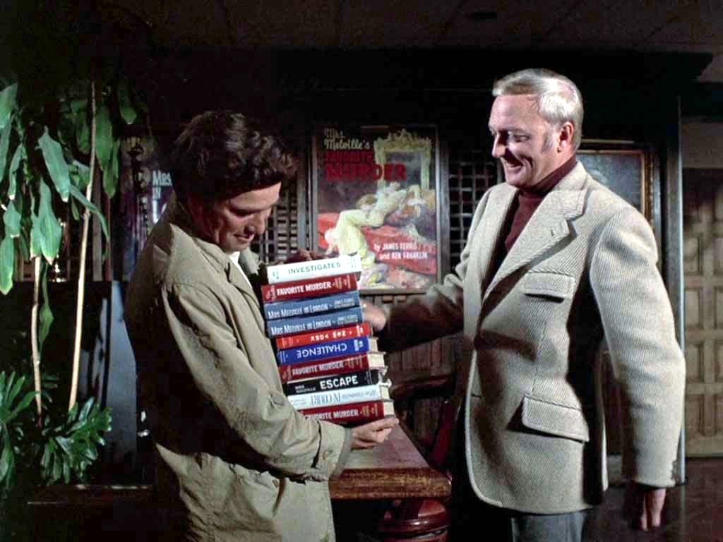 Lt. Columbo (Peter Falk) nearly buckles under the weight of 10 heavy books as Jack Cassidy smiles in Murder By the Book, Columbo’s pilot episode.