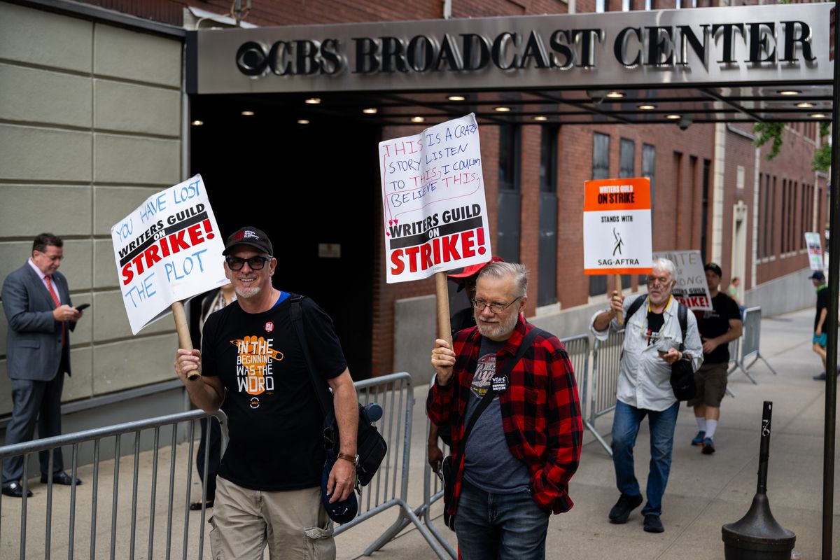Members of the WGA-EAST and SAG-AFTRA walk and carry picket signs outside of The Drew Barrymore Show as audience members arrive ahead of the show at CBS Broadcast Center on September 12, 2023, in New York City.