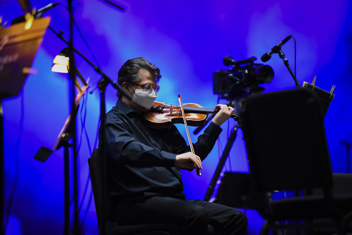 A masked violinist onstage.