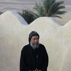 In this Tuesday, April 16, 2013 photo, Father Bakhomious stands on the roof of the ancient monastery of St. Anthony, southeast of Cairo, Egypt. In a cave high in the desert mountains of eastern Egypt, the man said to be the father of monasticism took refuge from the temptations of the world some 17 centuries ago. The monks at the St. Anthony’s Monastery bearing his name continue the ascetic tradition. But even they are not untouched by the turbulent times facing Egypt’s Christians, defiantly vowing their community’s voice won’t be silenced amid Islamists’ rising power. 