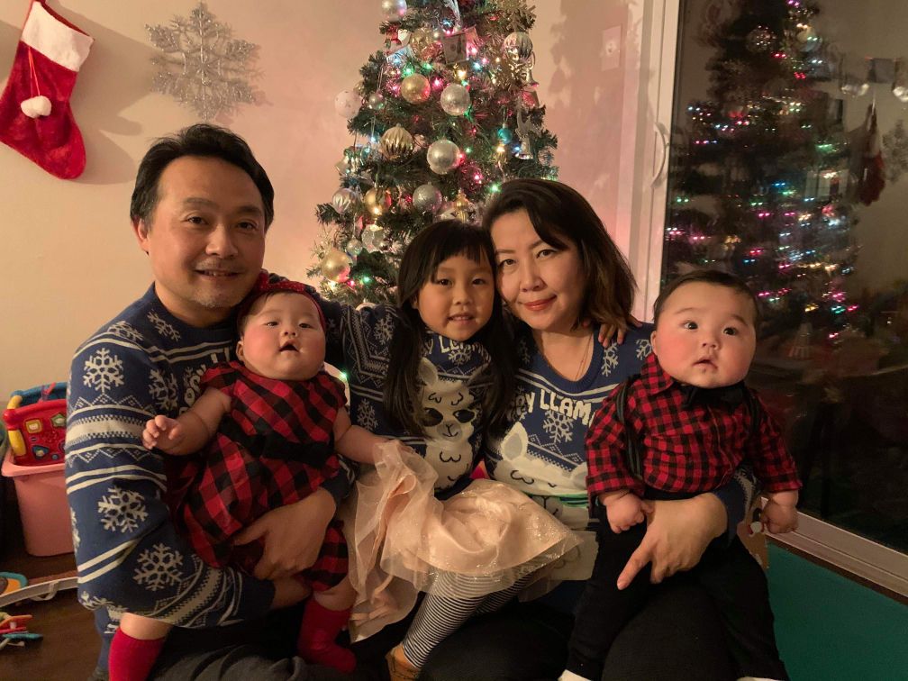 Chef Tetsuro Ozawa (left), his wife, and three young children pose for a family portrait at home in front of a Christmas tree