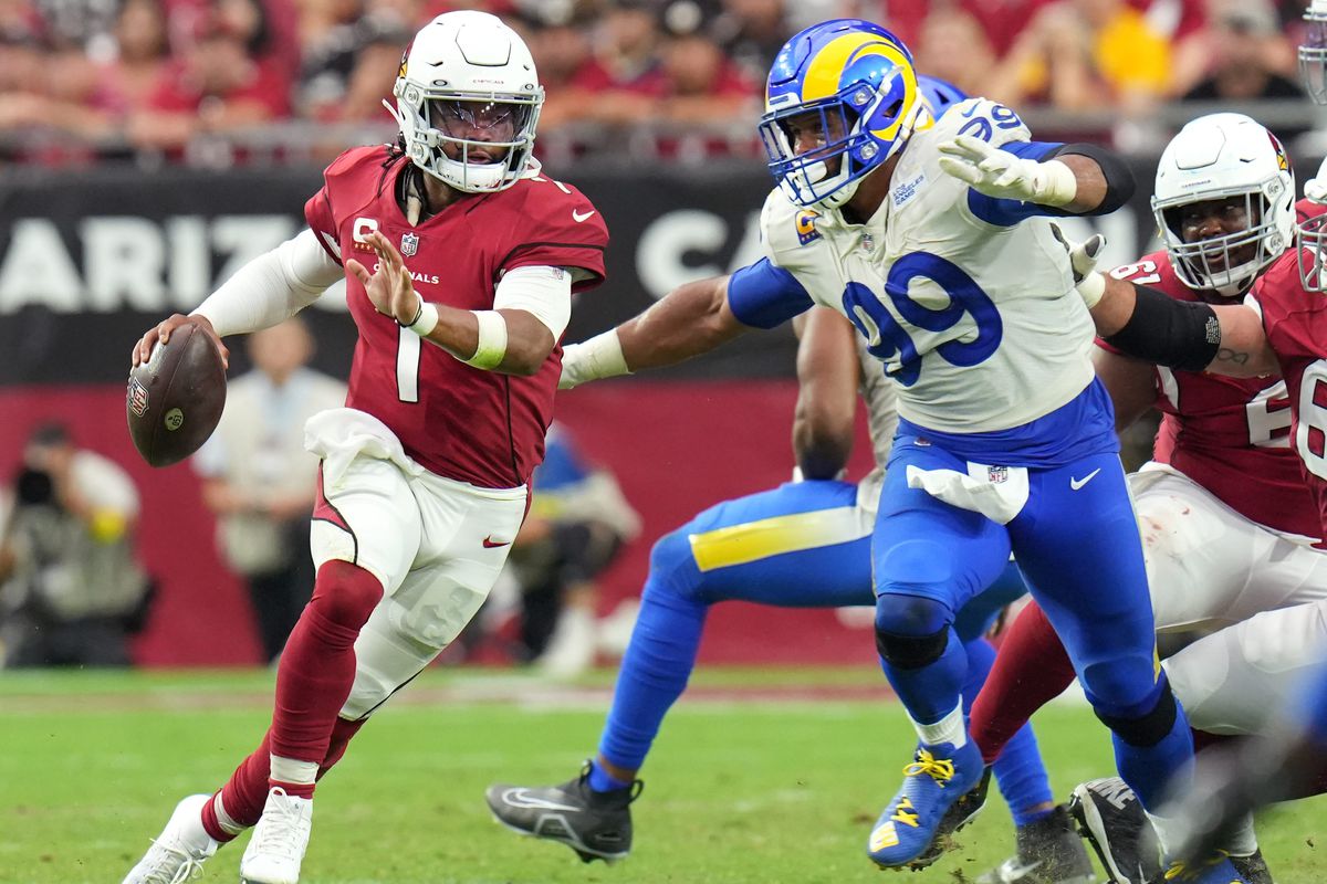 Arizona Cardinals quarterback Kyler Murray (1) scrambles out of the pocket as Los Angeles Rams defender Aaron Donald (99) chases him at State Farm Stadium.