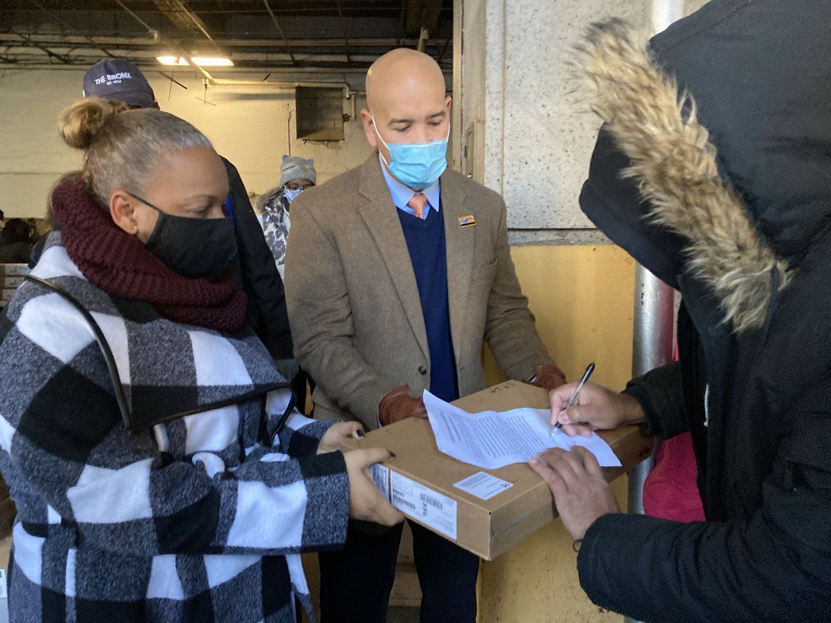 Meisha Ross Porter, left, helps distribute donated devices for remote learning this past January with Bronx Borough President Ruben Diaz Jr., center.
