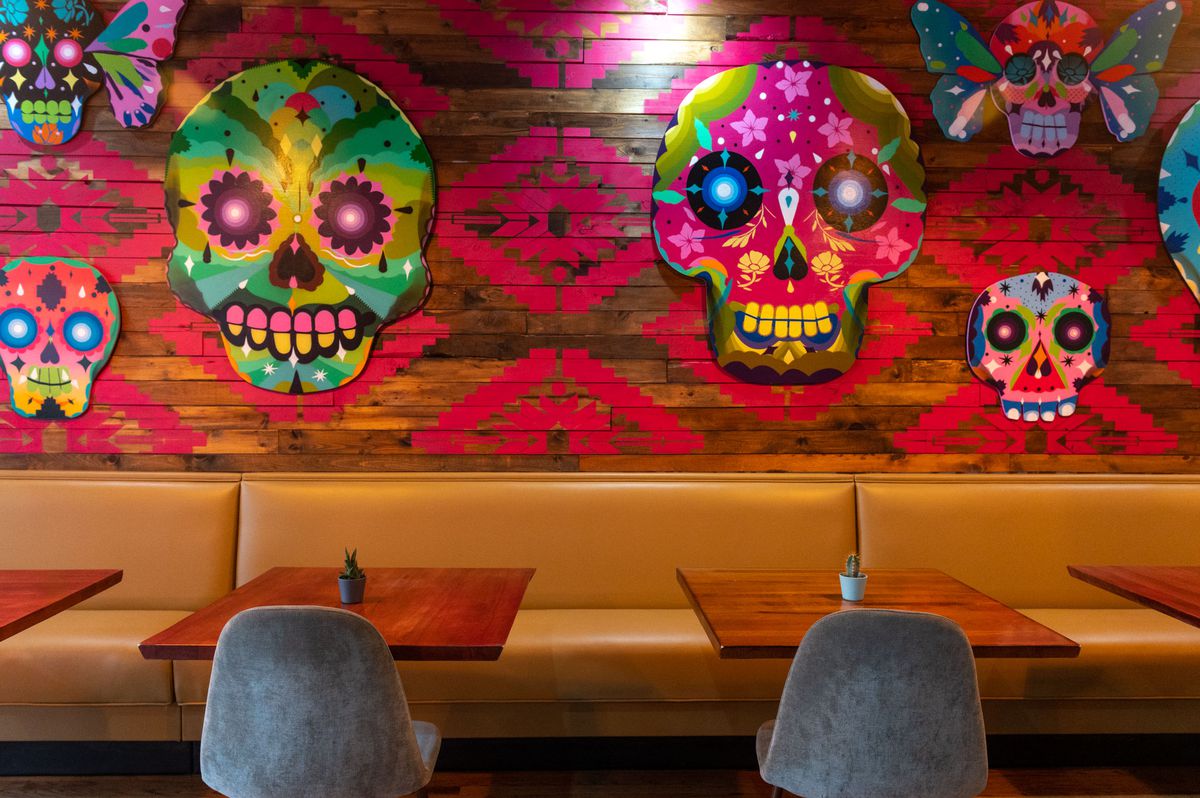 A brightly colored mural with Mexican art influences with skulls.