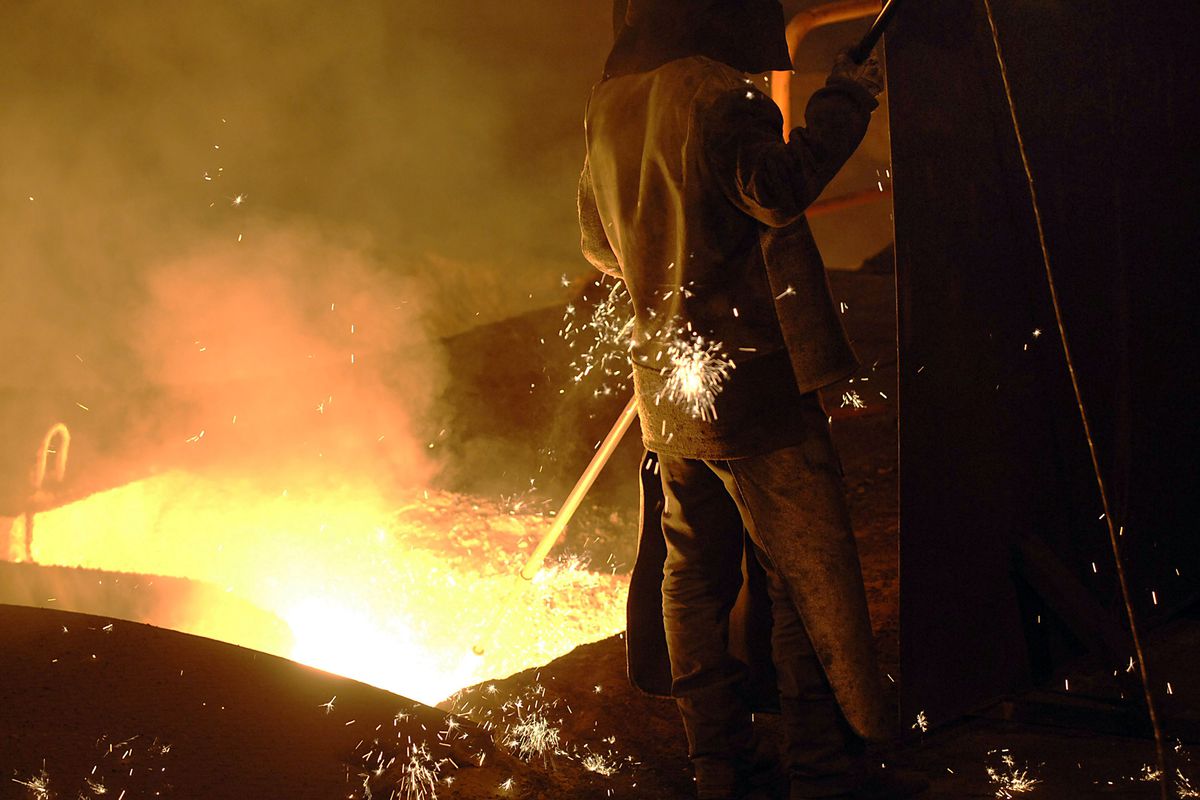 A steel worker takes a sample from a smelter at the Arcelor