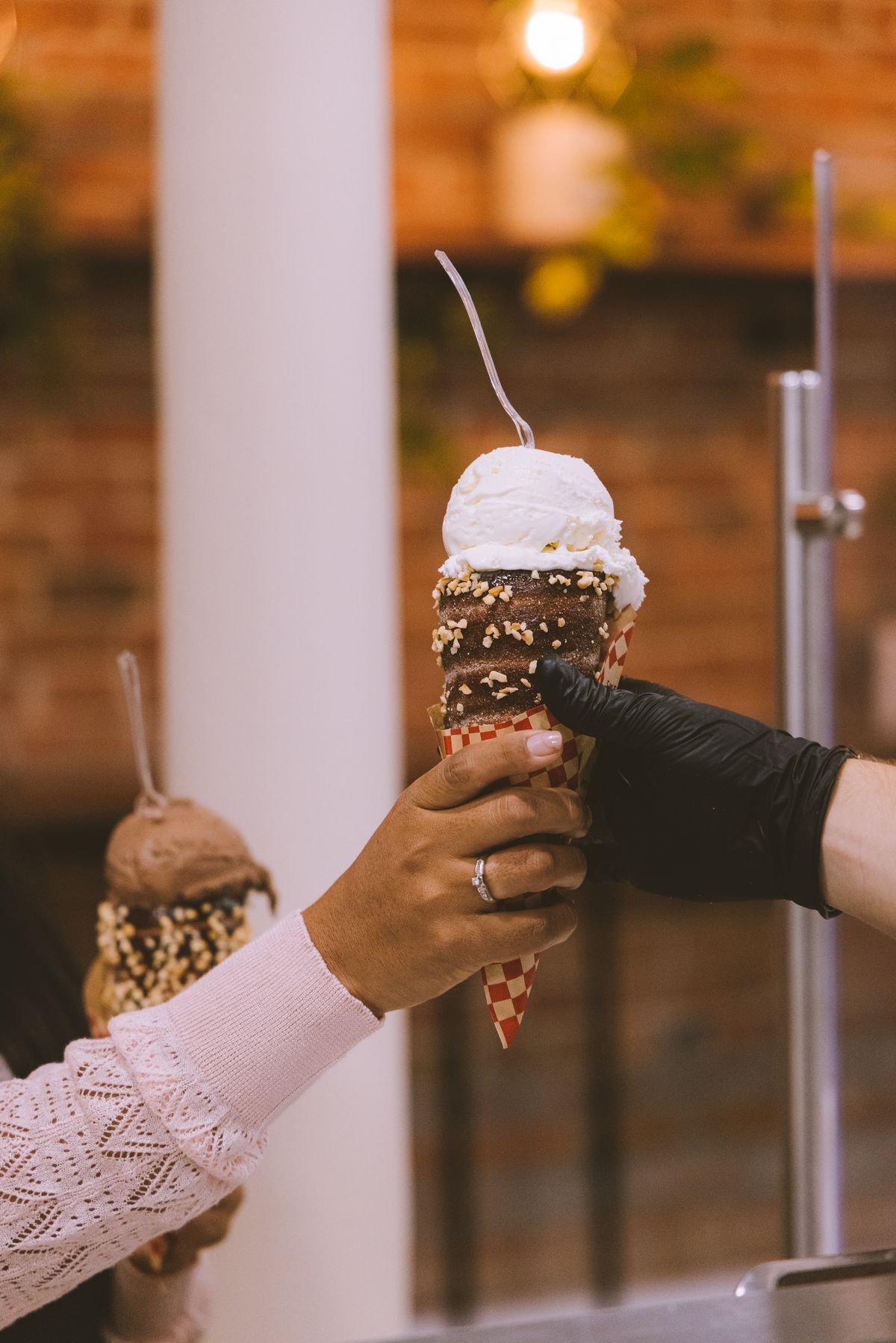 person handing off cone with ice cream