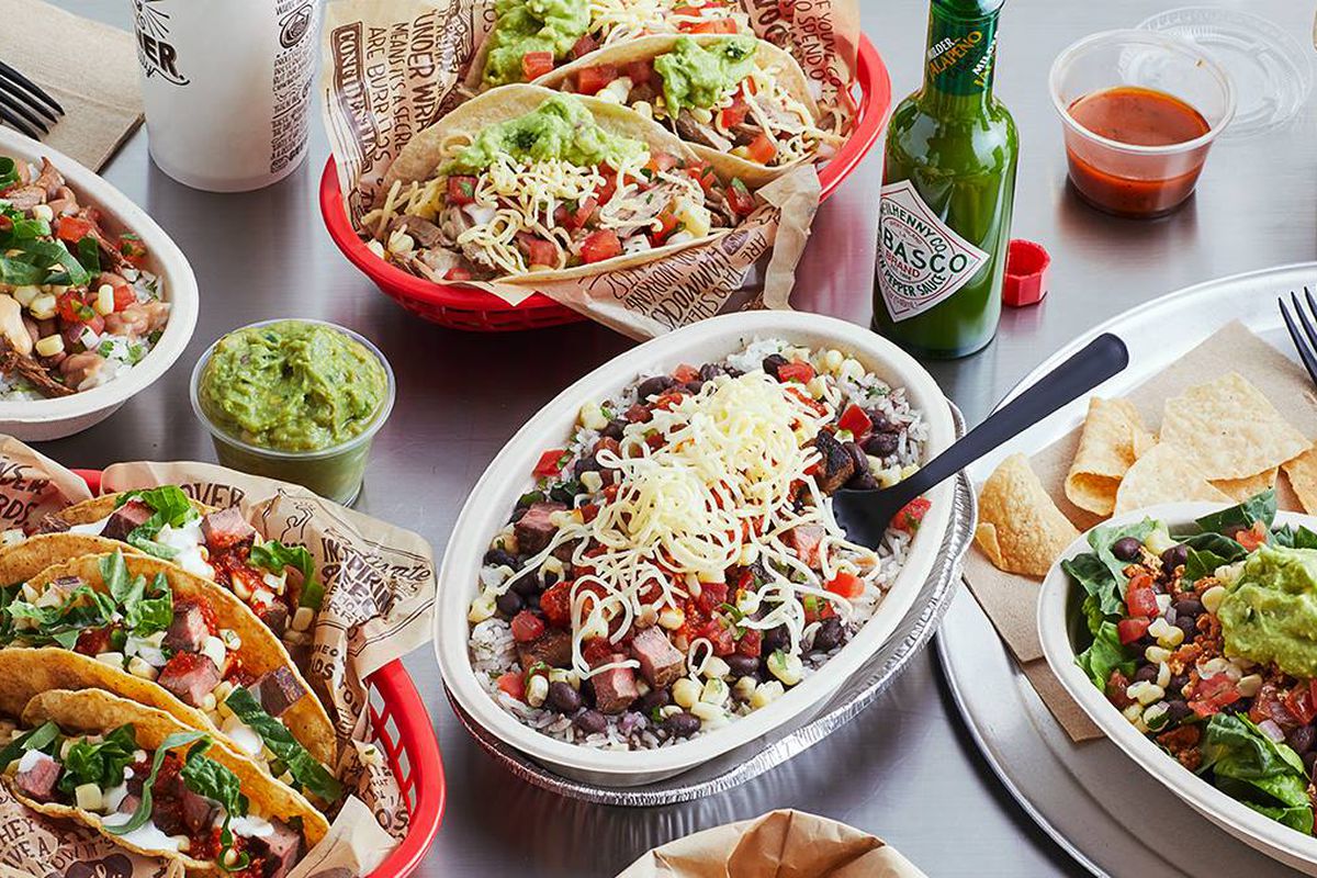 A table full of burritos and tacos from Chipotle