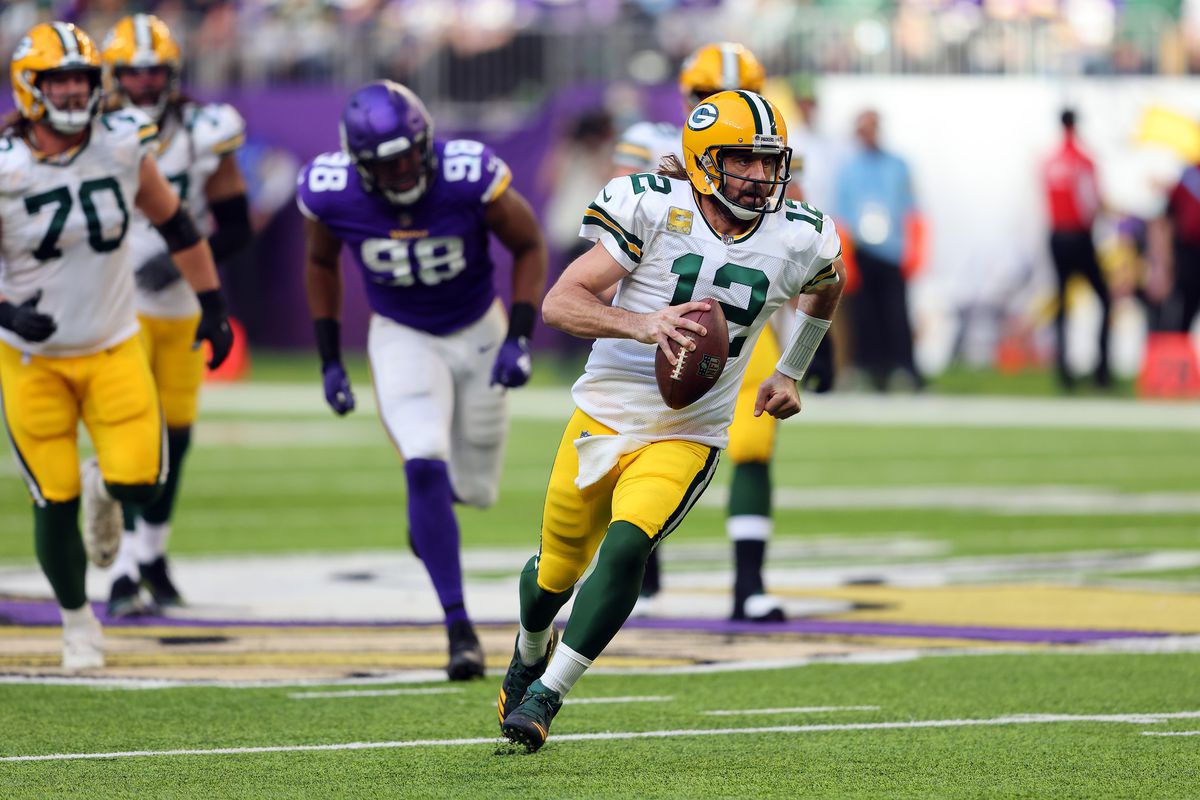 Aaron Rodgers #12 of the Green Bay Packers scrambles with the ball in the third quarter at U.S. Bank Stadium on November 21, 2021 in Minneapolis, Minnesota.