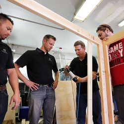 Travis Schmitt, left, and Steve Johns of Oakwood Homes, work with American Fork High School teachers Sandon Ellefson and Jeff Hill to build a playhouse at American Fork High School in American Fork on Thursday, Nov. 10, 2016. The playhouse will be sold at the Festival of Trees.