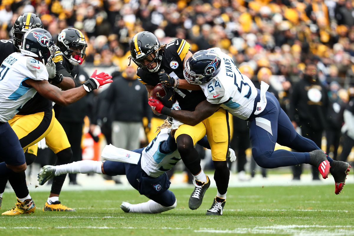 Rashaan Evans of the Tennessee Titans tackles Chase Claypool of the Pittsburgh Steelers during an NFL game at Heinz Field on December 19, 2021 in Pittsburgh, Pennsylvania.