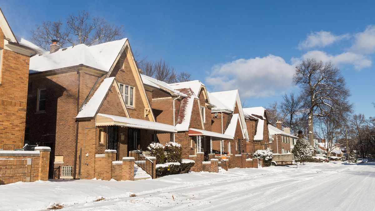 A row of snow-covered brick homes. 