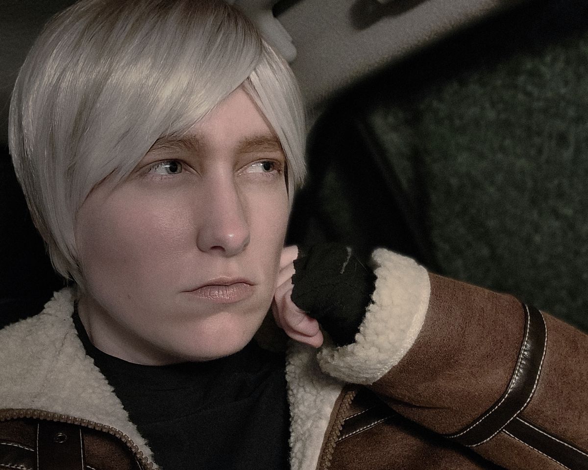 In full Leon Kennedy makeup and cosplay, the author mimics Leon’s pose at the outset of RE4 by moping in a car