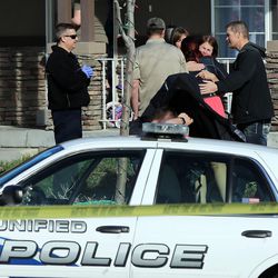 People hug at the scene of a fatal auto pedestrian accident in Magna on Monday, March 7, 2016. 
