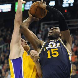 Utah Jazz power forward Derrick Favors (15) fights his way to the basket as Los Angeles Lakers center Chris Kaman (9) defends during a game at EnergySolutions Arena on Friday, Dec. 27, 2013.