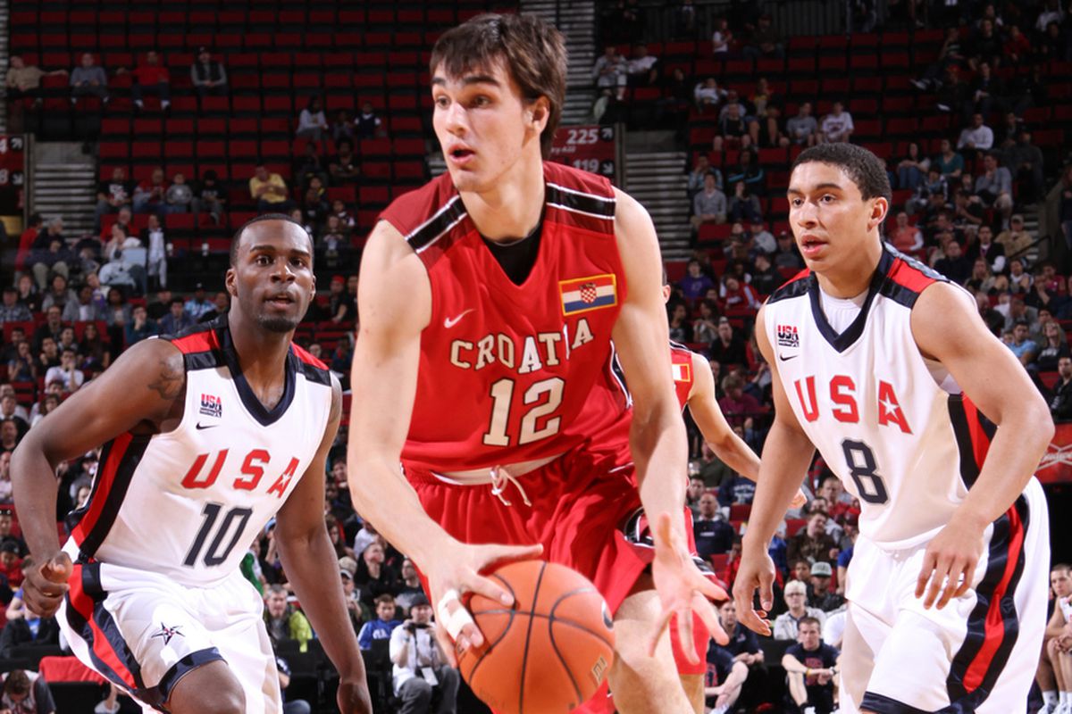 PORTLAND, OR - APRIL 7: Dario Saric #12 of the World Select Team drives against Shabazz Muhammad #10 and James Robinson #8 of the USA Junior Select Team during the 2012 Hoop Summit on April 7, 2012 at the Rose Garden Arena in Portland, Oregon. 