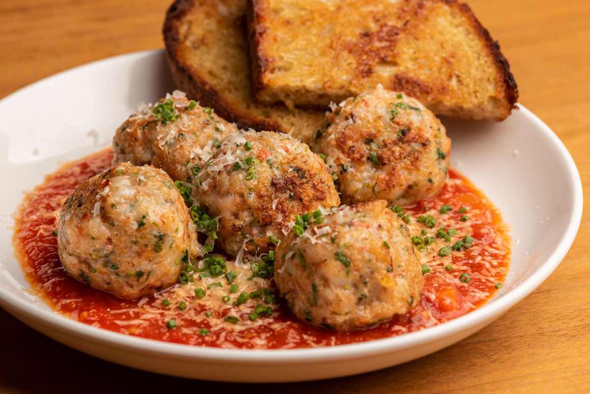 Five shrimp meatballs with toast and red tomato sauce.