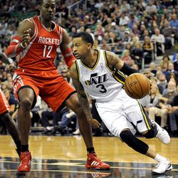 Utah Jazz point guard Trey Burke (3) drives around the defense of Houston Rockets power forward Dwight Howard (12) during a game at EnergySolutions Arena on Monday, Dec. 2, 2013.