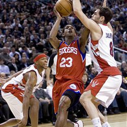 Philadelphia 76ers' Louis Williams drives to the net between Toronto Raptors' Jose Calderon, right, and Antoine Wright during the first half.