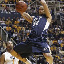 Pittsburgh's Gary McGhee (52) dunks in front of West Virginia's Da'Sean Butler, left, in the first half.