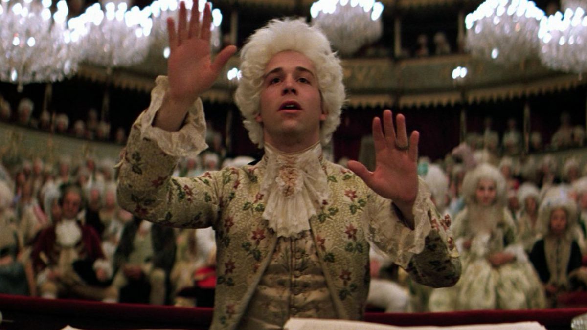 Wolfgang Amadeus Mozart with hands outstretched, conducting a symphony in Amadeus