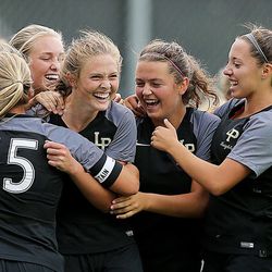 As the game ends, Lone Peak players swarm teammate Katie Houston, celebrating her game-winning goal as the Knights defeat the Miners at Lone Peak on Tuesday, Aug. 22, 2017,  2-1.