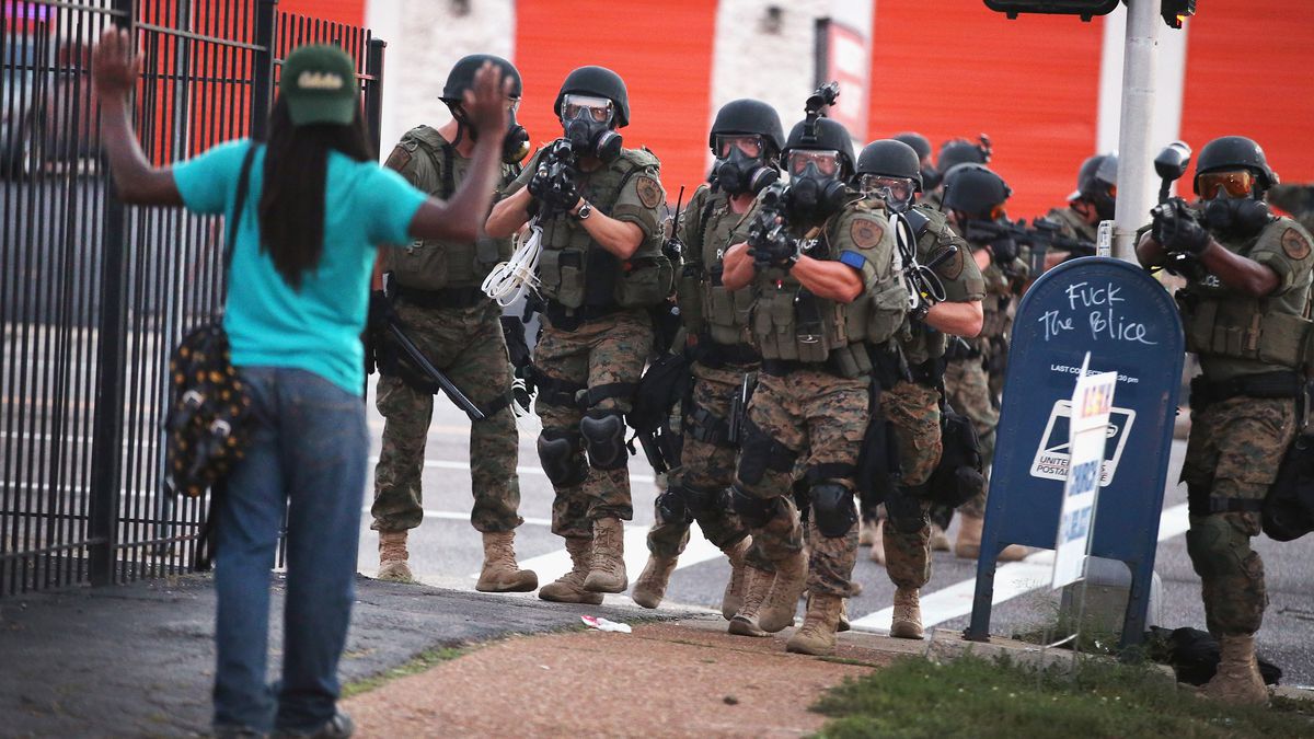 A man holds his hands up as he's confronted with police in Ferguson.