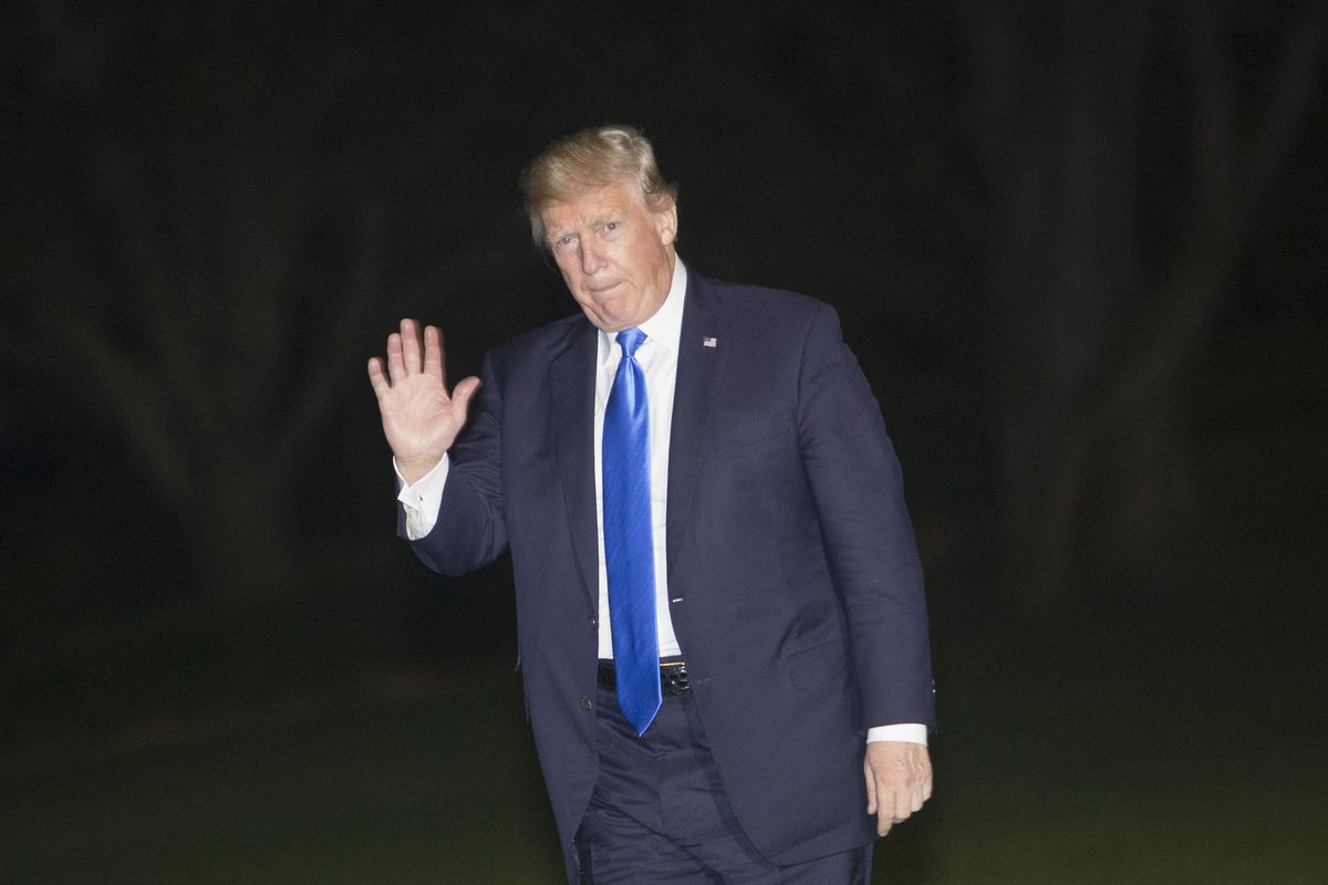 President Trump waves to photographers as he returns to the White House.