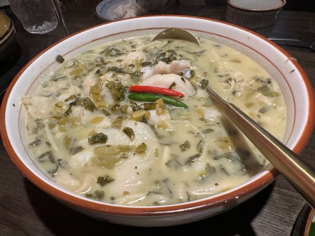 A white broth laced with fish, mushrooms, and chiles.