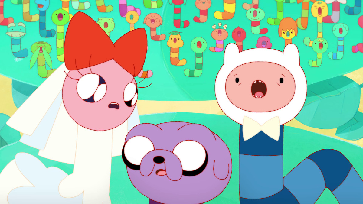 A pink caterpillar with a red bow, a purple caterpillar version of Jake the Dog, and a blue caterpillar version of Finn the Human in the “Food Chain” episode of Adventure Time.