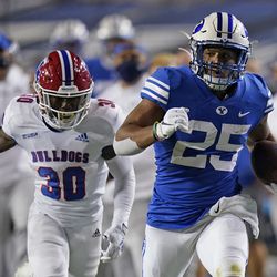 BYU running back Tyler Allgeier (25) carries the ball as Louisiana Tech defensive back Cedric Woods (30) pursues during the second half of an NCAA college football game Friday, Oct. 2, 2020, in Provo.