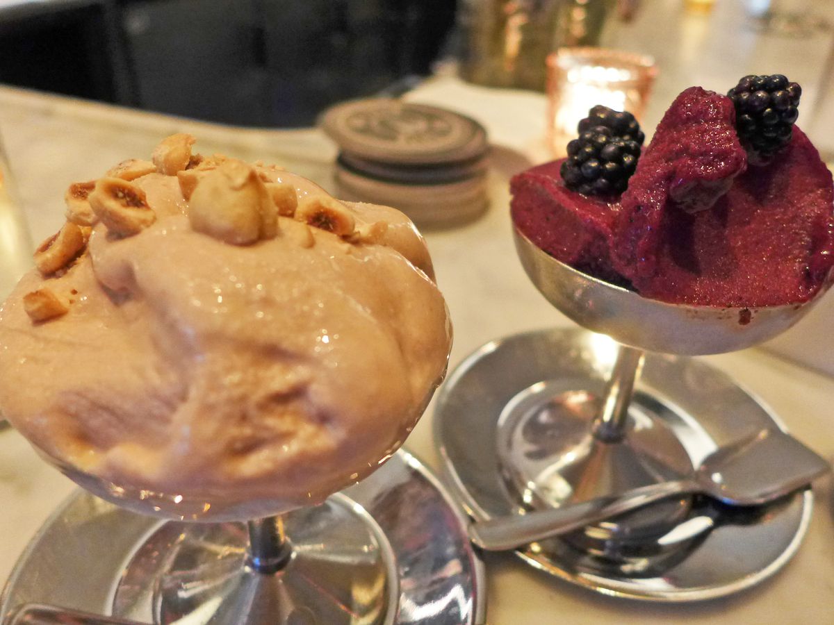 A scoop of beige and scoop of deep purple ice cream.