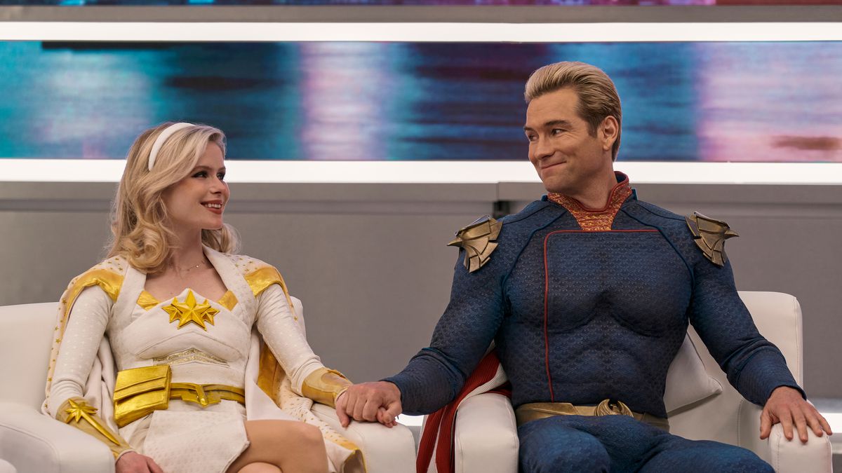 Homelander and Starlight sit on a talk show, pretending to smile at each other for the camera in The Boys season 3. 