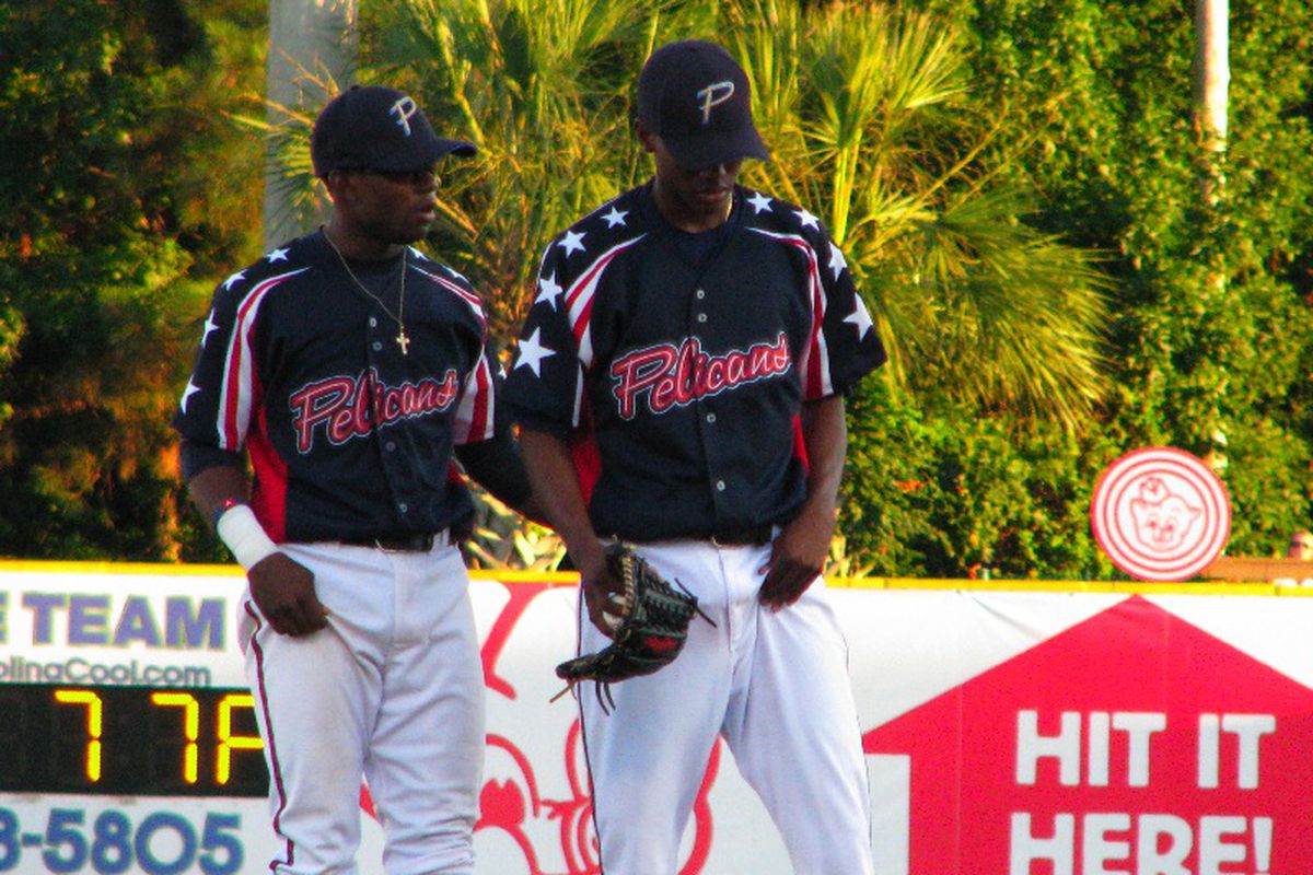 Displaying his on-field leadership, Mycal Jones (left) helps Julio Teheran (right) get through some trouble on the bases.