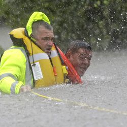 Wilford Martinez, right, is rescued from his flooded car by Harris County Sheriff's Department Richard Wagner along Interstate 610 in floodwaters from Tropical Storm Harvey on Sunday, Aug. 27, 2017, in Houston, Texas.