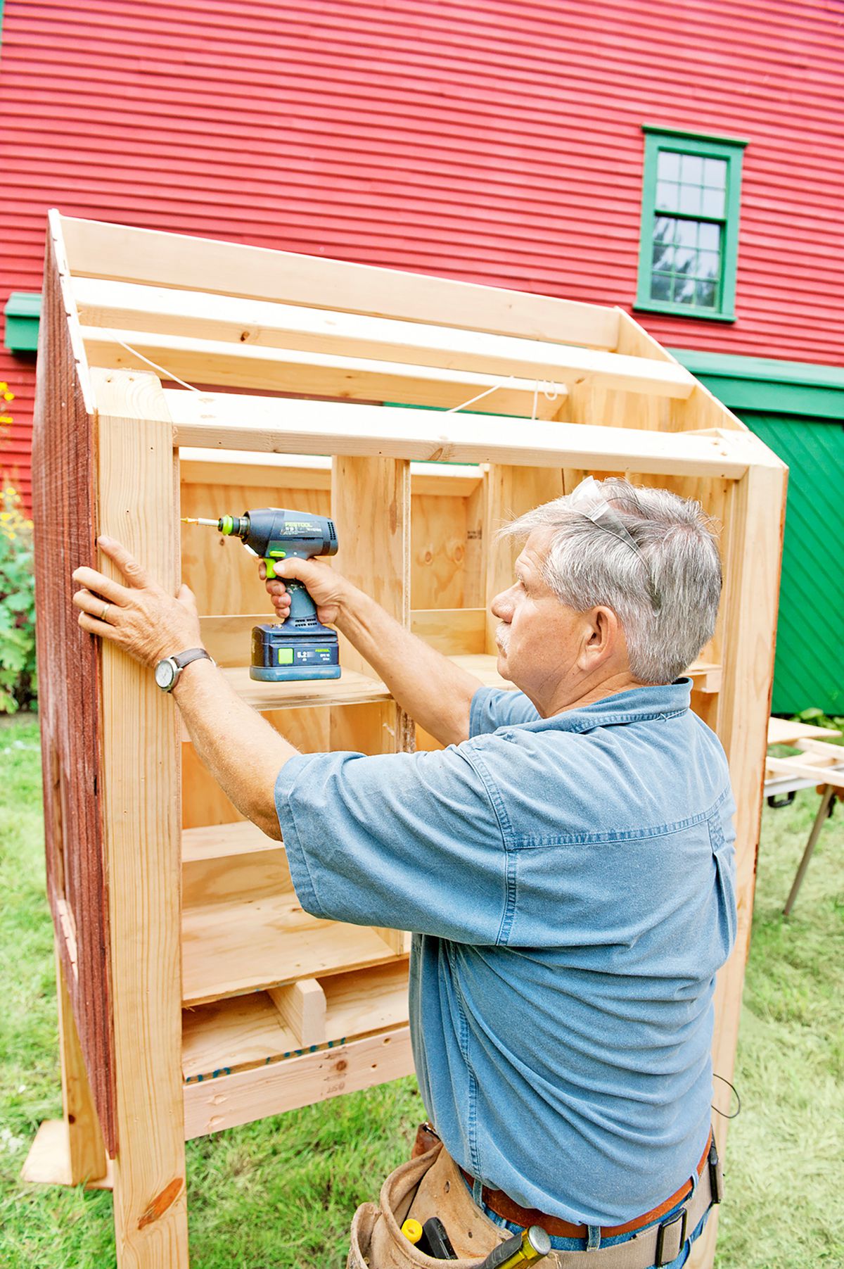 Tom Silva installing nesting boxes into a chicken coop.