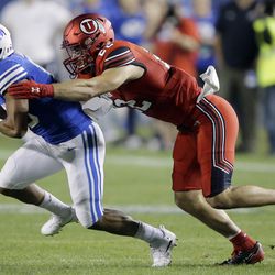 Utah defensive back Chase Hansen, right, tackles a BYU receiver during Saturday's game in Provo, Utah.