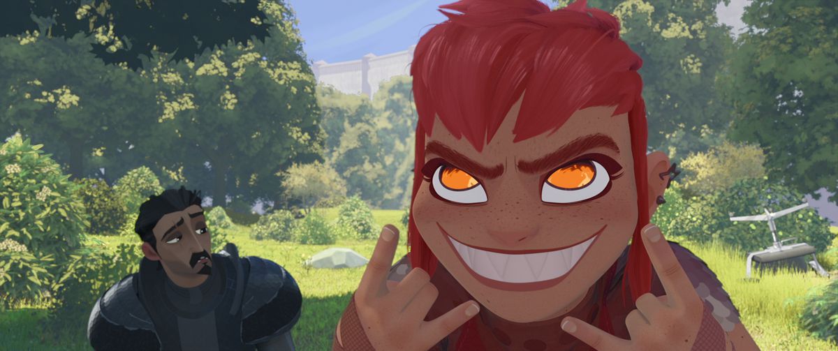 (L-R) A Knight (Riz Ahmed) stares at a red-haired girl (Chloë Grace Moretz) smiling with pointed teeth and yellow eyes with her hands throwing up horns in Nimona.