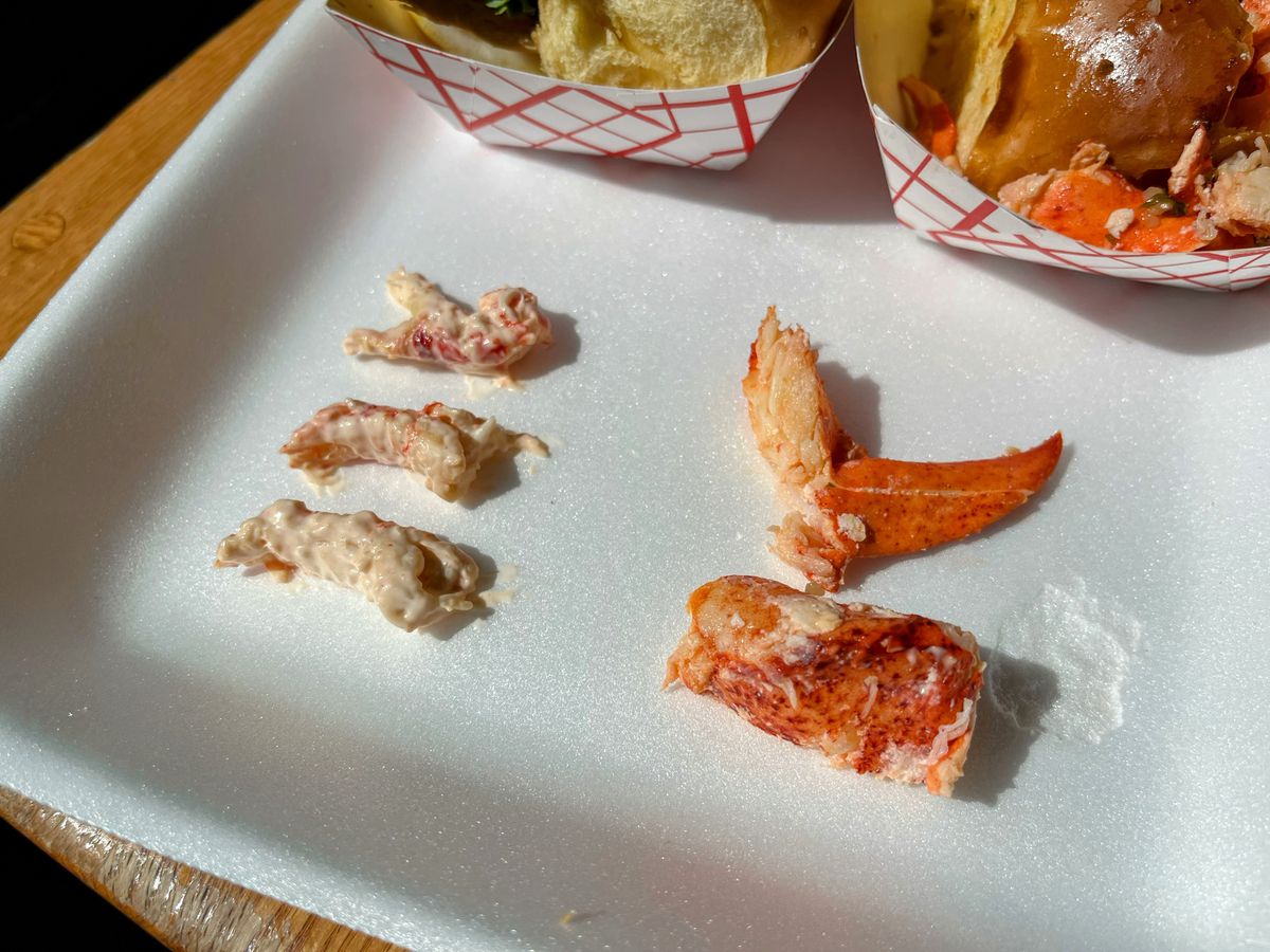 Crawfish and lobster meat laid out on a white styrofoam tray with the rolls visible in the background.